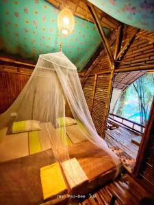 Ao LukKRABI BAMBOO KINGDOM at AOLUEK PARADISE的一张位于带蚊帐的房间内的床铺