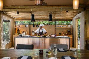 维多利亚瀑布Tsowa Safari Island的厨师在厨房里准备食物,厨房里设有桌子