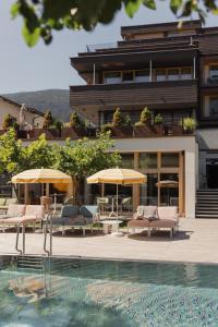 齐勒谷地里德Mari Pop Hotel的酒店设有带椅子和遮阳伞的游泳池