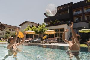 齐勒谷地里德Mari Pop Hotel的两人在游泳池玩球