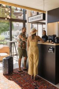 齐勒谷地里德Mari Pop Hotel的站在柜台的戴帽子的女人