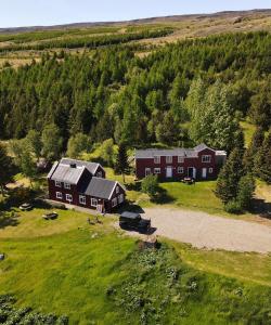 埃基斯蒂尔Hengifosslodge Skáldahús的田野上大红房子的空中景色