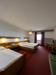 塞尔瓦迪加尔代纳山谷Rifugio Frara的酒店客房设有两张床和一张桌子。
