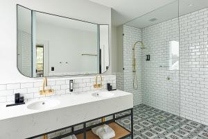 波塔灵顿Portarlington Grand Hotel的一间带两个盥洗盆和大镜子的浴室