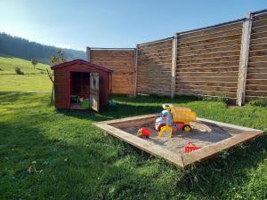 蒂蒂湖-新城Ferienhaus Kaltenbach的沙箱,沙子里有玩具,在院子里