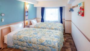 TsushimaToyoko Inn Tsushima Hitakatsua的酒店客房设有两张床和窗户。