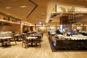 高雄Kaohsiung Marriott Hotel 高雄万豪酒店的配有桌椅的餐厅以及厨师准备食物