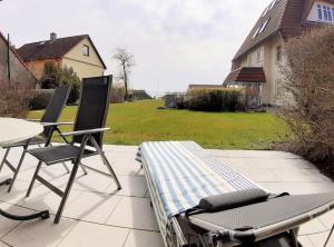 布雷格Hafenglück的庭院配有两把椅子、一张床和一张桌子