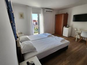 苏佩塔尔Apartmani Neva Supetar的一间卧室设有一张大床和一个窗户。
