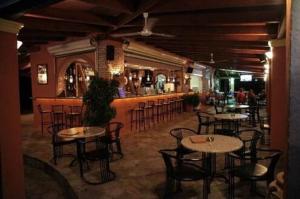 阿尔米罗斯海滩Hellens Village的一间带桌椅的餐厅和一间酒吧