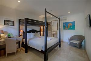 八丹拜OK潜水度假酒店及Spa的一间卧室配有一张天蓬床、一张书桌和一张书桌