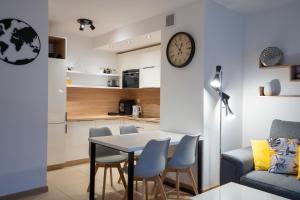 斯克拉斯卡波伦巴RentPlanet - Apartamenty Górna Resorts的客厅配有桌椅和时钟
