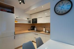 斯克拉斯卡波伦巴RentPlanet - Apartamenty Górna Resorts的厨房配有白色橱柜和墙上的时钟