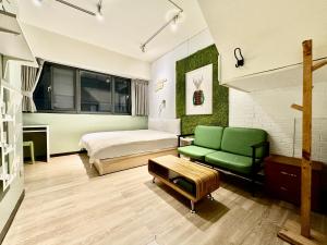台中市御旅 Inn的一间卧室配有一张床和一张绿色沙发