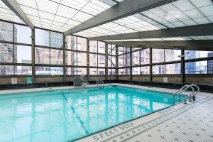 纽约Murray Hill 1BR w Doorman Gym Pool Parking NYC-583的一座大型游泳池,位于一座带窗户的建筑内