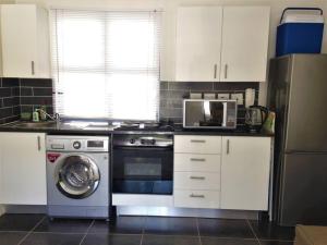 开普敦The Rondebosch on Belmont的厨房配有洗衣机和微波炉。