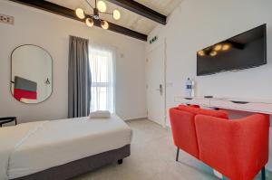 瓦莱塔Casa Domenico 8的一间卧室配有一张床和两张红色椅子