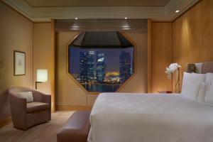 新加坡The Ritz-Carlton, Millenia Singapore的卧室设有一张白色大床和一扇窗户。