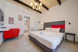 瓦莱塔Casa Domenico 6的一间卧室配有一张大床和一张红色椅子