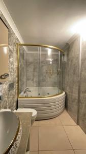 特拉布宗Caykent Suites Deluxe Hotel的带浴缸、卫生间和盥洗盆的浴室