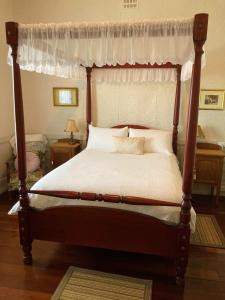 班伯里Rose Cottage的卧室配有带白色床单的天蓬床