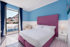 波西塔诺布甘维尔酒店的一间卧室设有一张大床和一个大窗户