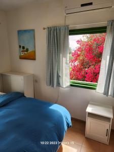 Tal ShaẖarTal Shahar room的一间卧室设有蓝色的床和窗户。