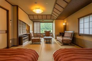 JozankeiJozankei Onsen Yurakusoan的一间卧室配有两张床和一张桌子及椅子