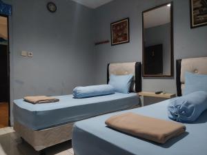 雅加达Pondok Seruni Kemanggisan Jakarta的两张睡床彼此相邻,位于一个房间里