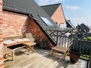 OnkerzeleZEN op Vakantie - Zen aan De Gavers的砖砌建筑的阳台,配有长椅和椅子