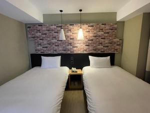 台北苓旅中山馆-Lininn ZhongShan的砖墙客房的两张床