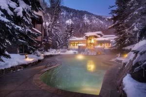 阿斯潘Luxury 2 Bedroom Downtown Aspen Vacation Rental With Access To A Heated Pool, Hot Tubs, Game Room And Spa的雪中带游泳池的房子