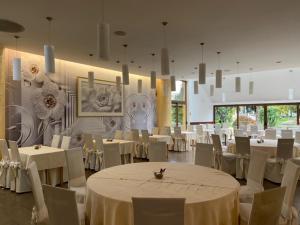 ÐurđevacHotel Picok的宴会厅配有白色的桌子和白色的椅子