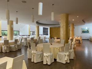 ÐurđevacHotel Picok的宴会厅配有白色的桌子和白色的椅子