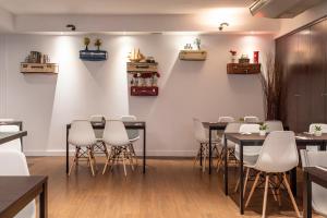 马德里珀蒂宫阿图罗索里亚阿尔卡拉酒店的用餐室配有桌子和白色椅子