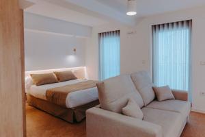 穆尔西亚Apartamentos Santa Isabel的一间卧室配有一张床和一张沙发