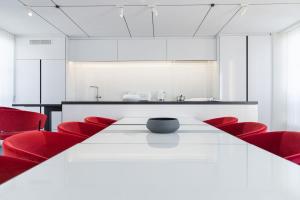 巴黎La Source Exclusive Apartment的一间会议室,配有白色的桌子和红色的椅子