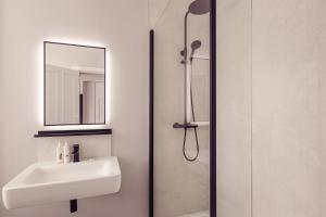 格拉斯米尔Tweedies Bar and Lodge的浴室配有盥洗盆和带镜子的淋浴