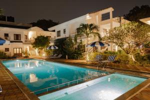 卡兰古特Rainforest - Casa Azure 5 Min walk to the beach的夜间在房子前面的游泳池