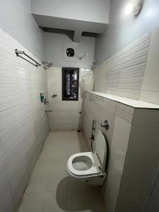 古瓦哈提Urban Inn Rukminigaon的白色的浴室设有卫生间和窗户。