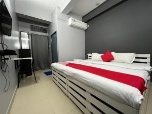 古瓦哈提Urban Inn Rukminigaon的一间卧室配有一张带红色毯子的大床