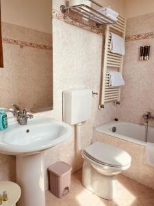 威尼斯科特罗莎酒店的浴室配有盥洗盆、卫生间和浴缸。