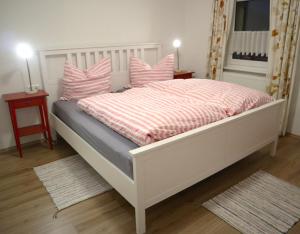 蒂蒂湖-新城Haus Schwedes的卧室配有白色床和粉红色枕头