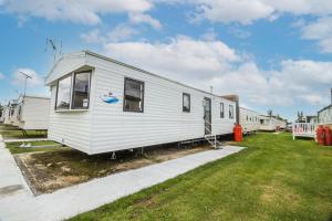 滨海克拉克顿8 Berth Caravan At Highfield Grange In Essex Ref 26267e的停在院子中的白色移动房屋