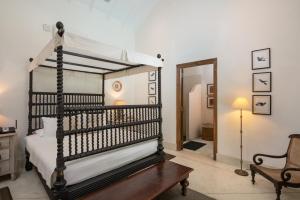 高尔Taru Villas Rampart Street - Galle Fort的一间卧室配有一张天蓬床和一把椅子
