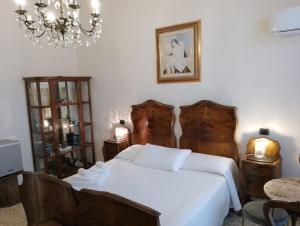 斯培西亚Glam Resort Luxury Lorenzo的卧室配有白色的床和吊灯。