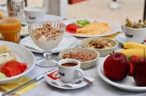 希马拉Apartments Piazza的餐桌,盘子上放着食物和咖啡