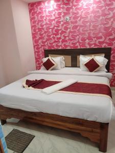 普里Goroomgo Puri Inn Puri Near Sea Beach - Great Location的一间卧室配有一张粉红色墙壁的床
