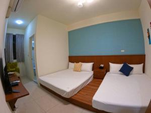 金宁乡熊宝贝民宿的一间卧室设有两张床和蓝色的墙壁