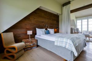 凯图姆Kontorhaus Keitum的一间卧室设有一张带木墙的大床